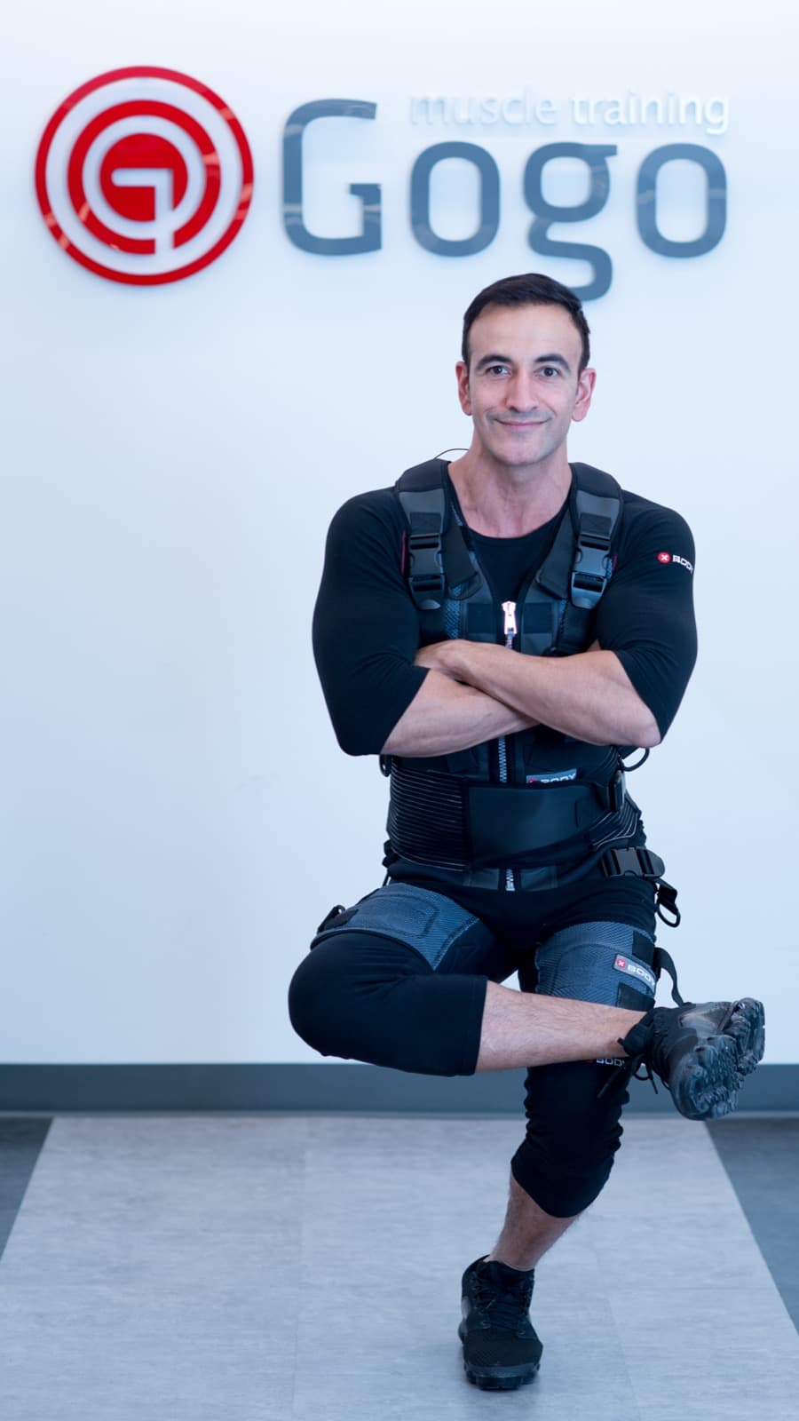 A client holding a lunge in a fitted XBody EMS suit during a session at GoGo Muscle Training